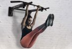 mujer haciendo ejercicios en barra de dominadas